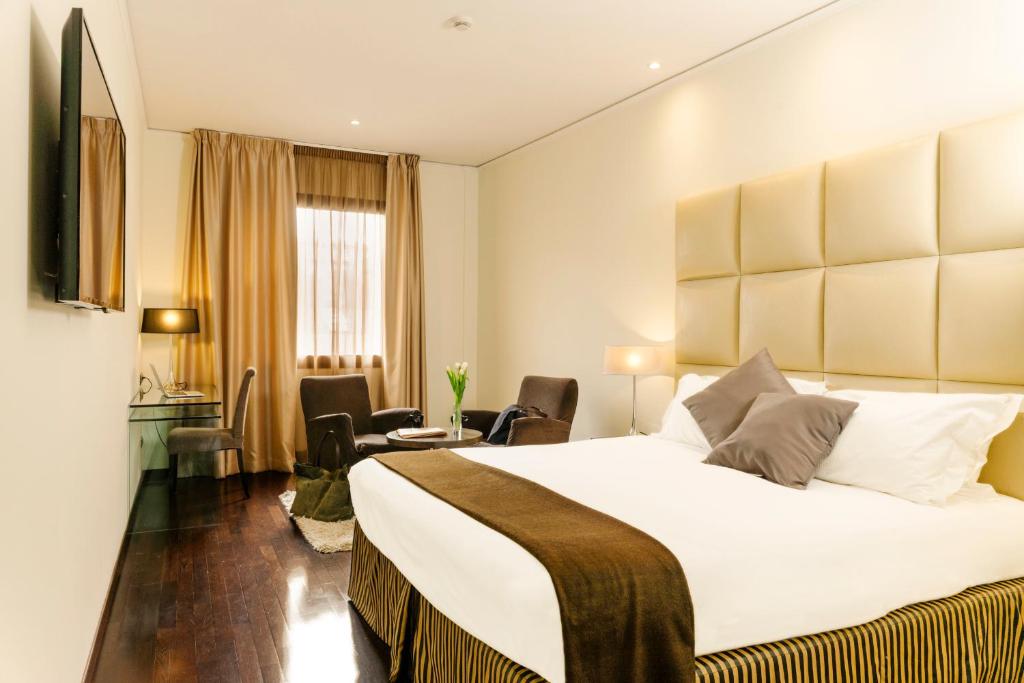 佛罗伦萨大都市酒店的酒店客房设有一张大床和一张书桌。