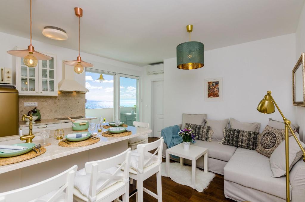 杜布罗夫尼克Apartment Rose Dubrovnik的厨房以及带沙发和桌子的客厅。