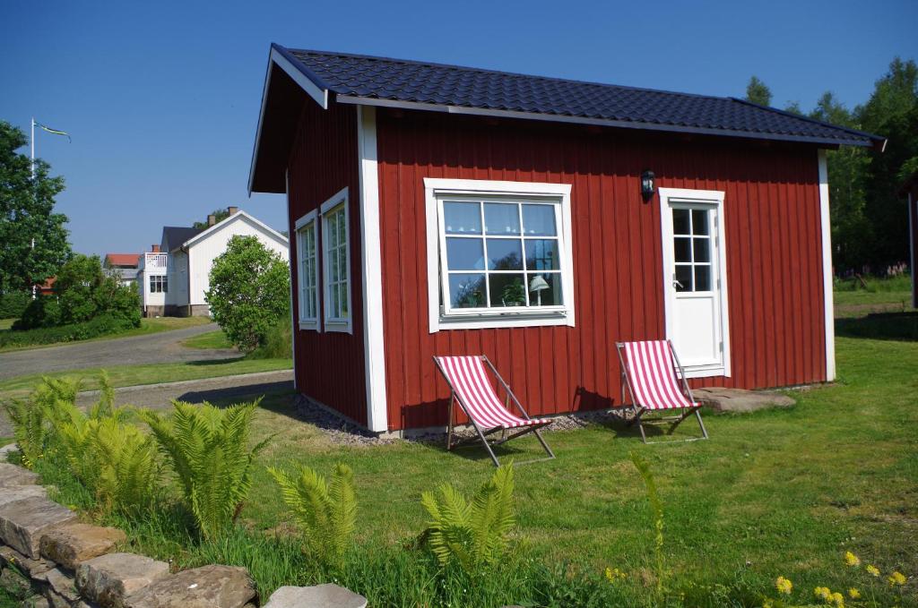 DalstorpEkereds Gårdsstuga的院子里有两把椅子的红色小房子