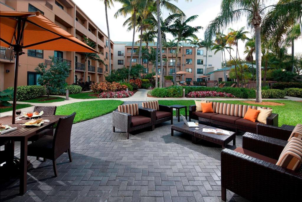 迈阿密湖迈阿密湖万怡酒店的一个带沙发和桌子的庭院。