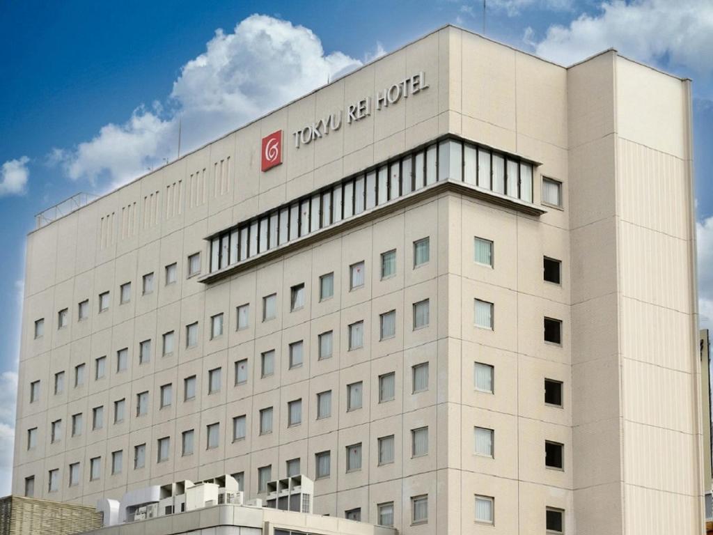 长野长野东急REI饭店的白色的建筑,上面有标志