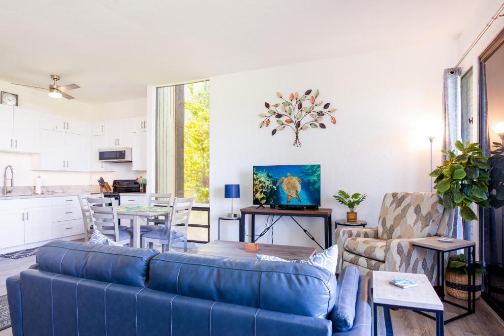 唯客乐渡假村Waikoloa Villages E108的一间带蓝色沙发的客厅和一间厨房