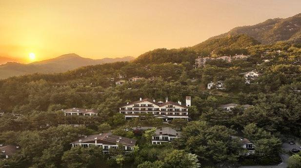 堤川市Club ES Jecheon Resort的山丘上一组有太阳的房屋
