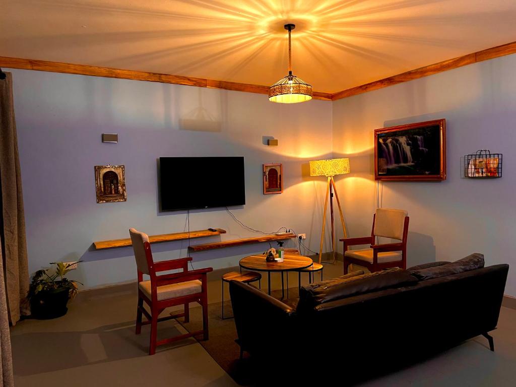 阿鲁沙City Retreat Arusha的带沙发和电视的客厅