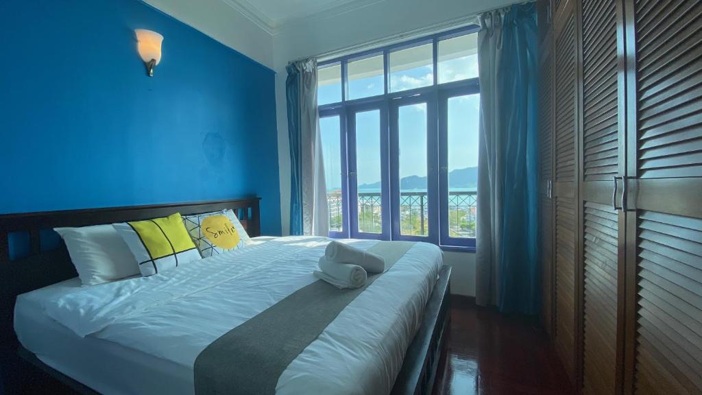 瓜埠Sugar Marina Seaview Families Suite Apartment的蓝色卧室设有一张带大窗户的床