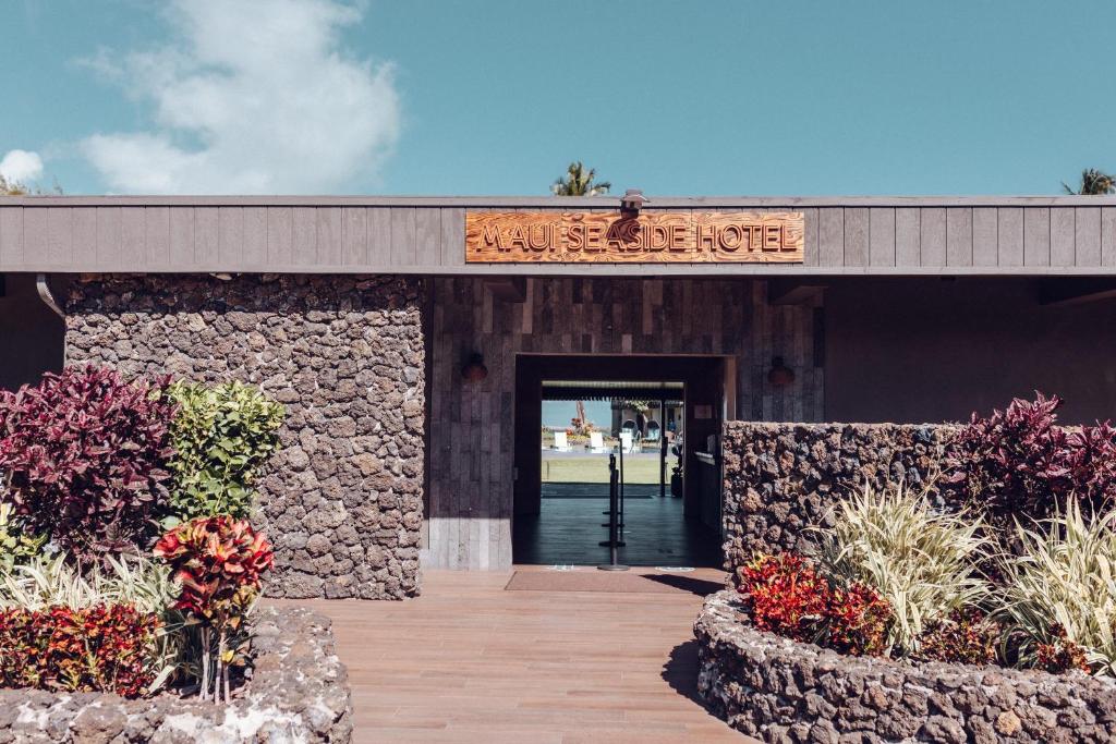 卡胡卢伊Maui Seaside Hotel的一座建筑,上面有标志,欢迎客人来到旅馆