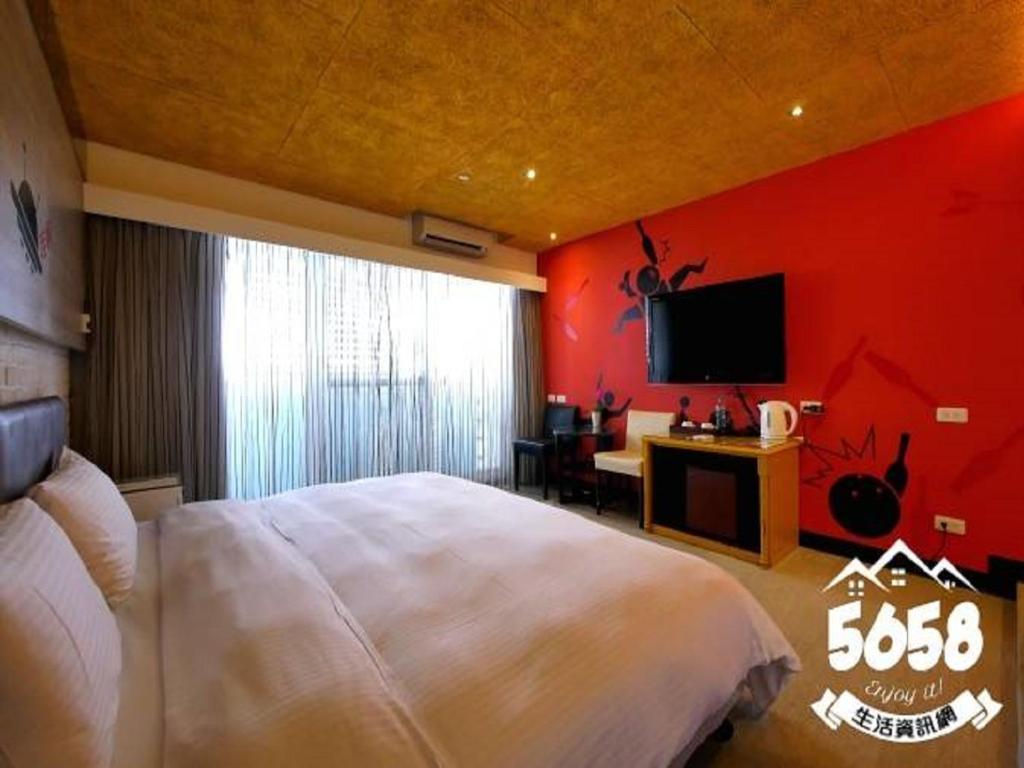 高雄R8环保商旅的卧室配有白色的床和红色的墙壁