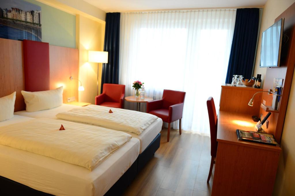 杜塞尔多夫Hotel National Düsseldorf (Superior)的配有一张床、一张书桌和一扇窗户的酒店客房