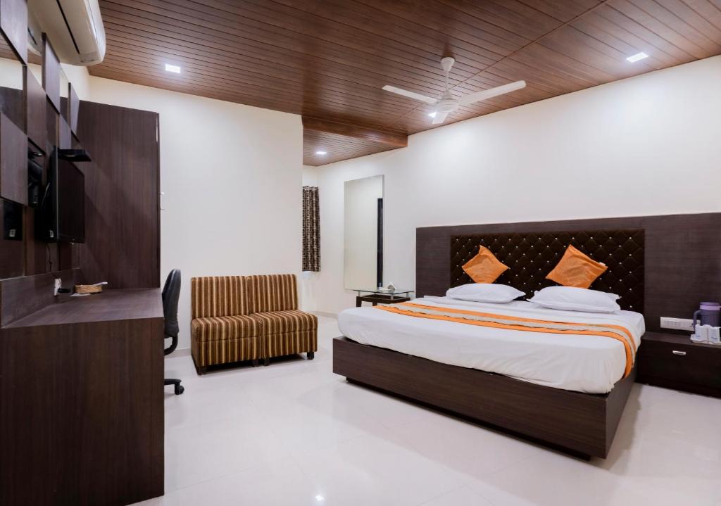 艾哈迈达巴德阿希什酒店的配有一张床和一把椅子的酒店客房