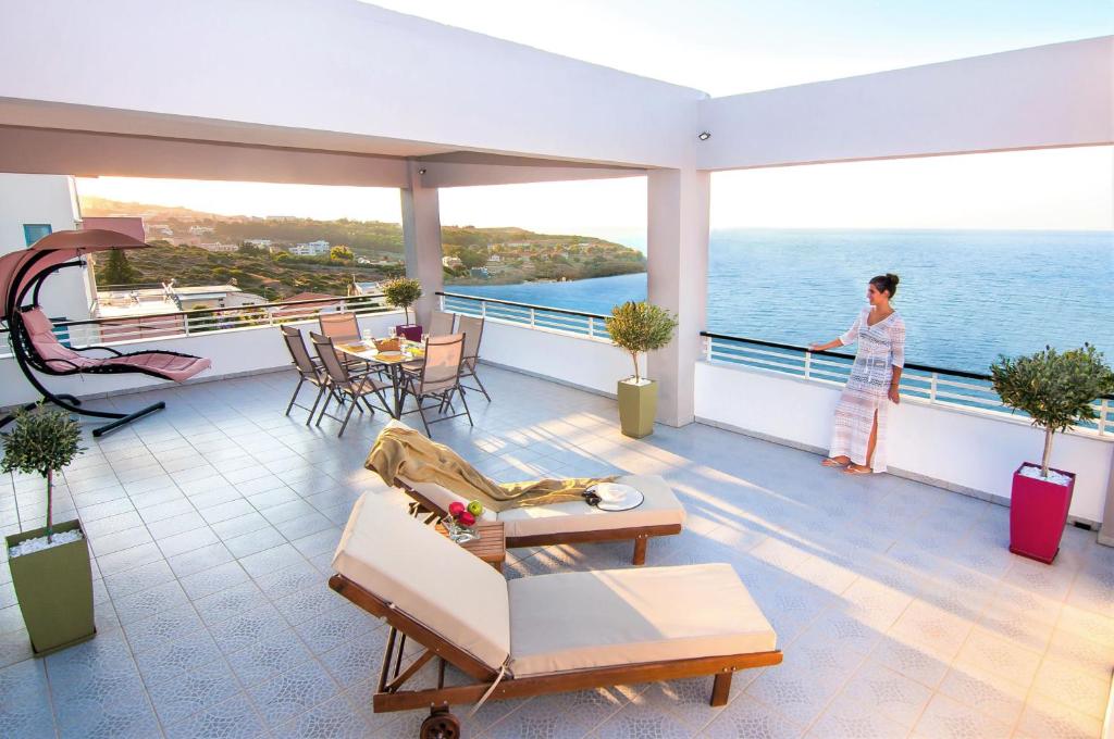 罗希姆诺Villa Sea Horizon的站在一个眺望海洋的阳台上的女人
