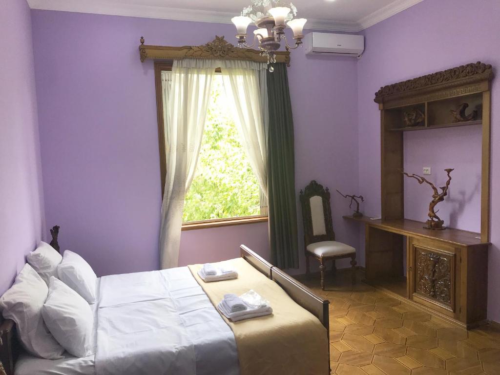 库塔伊西Wooden Museum的卧室设有紫色墙壁、床和窗户