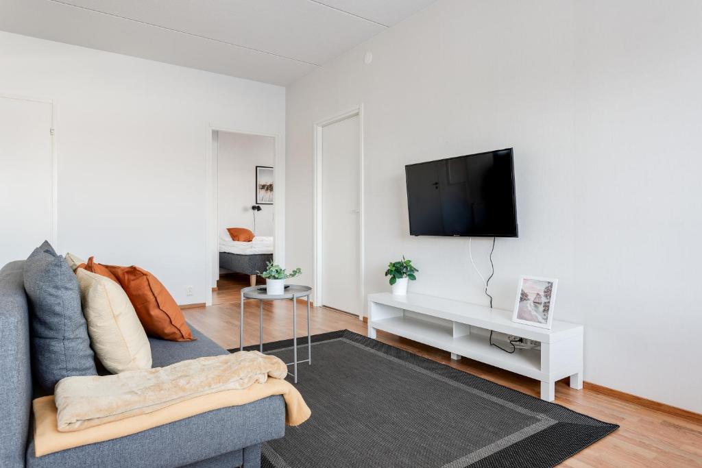 坦佩雷Hiisi Homes Tampere Muotiala的带沙发和平面电视的客厅