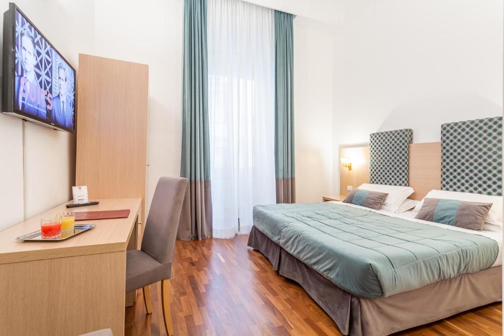 罗马美第奇酒店的配有一张床和一张书桌的酒店客房