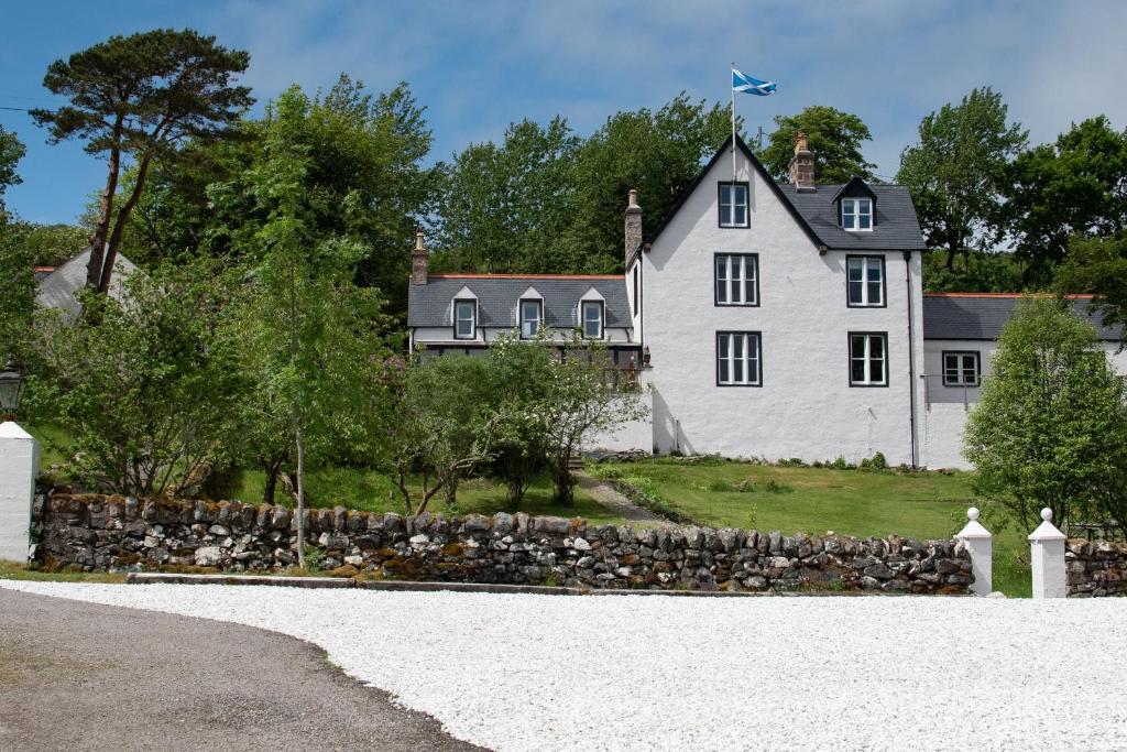 洛欣弗The Albannach的一座白色的大房子,设有石墙