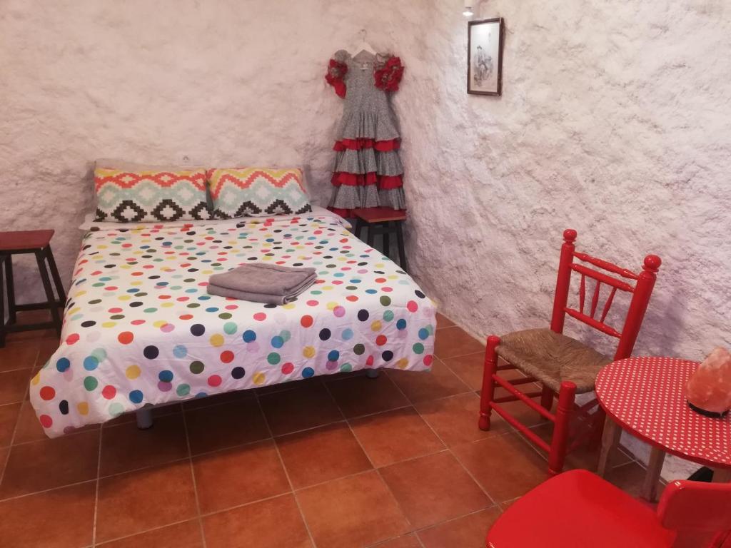 格拉纳达CUEVA EL DUENDE的卧室配有一张床和一张桌子及椅子