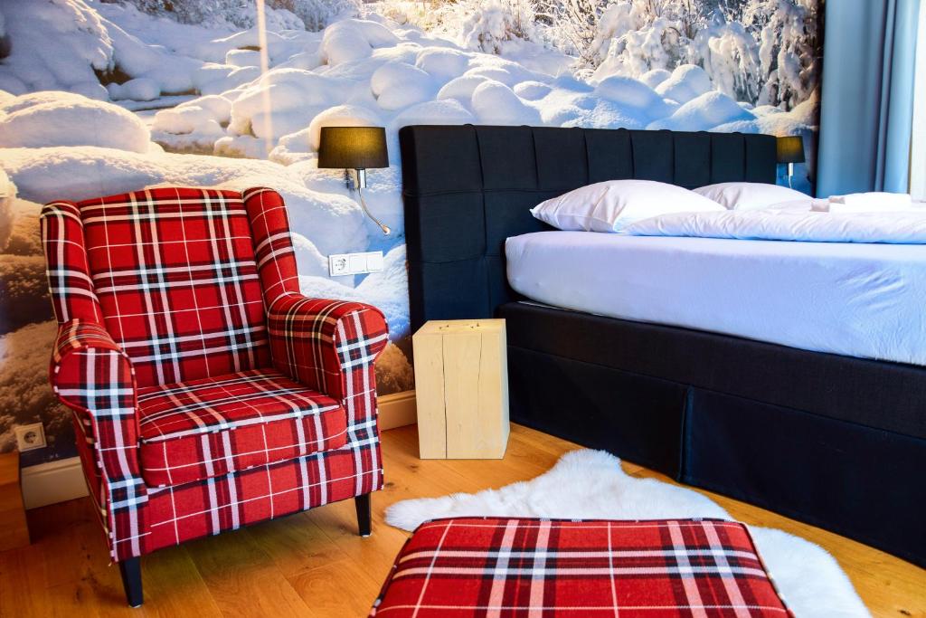 因泽尔ALPENLIEBE Design Hotel的一间卧室配有一张椅子和一张床