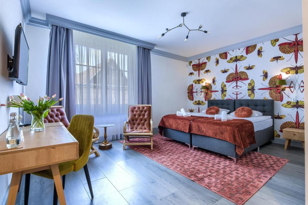 卡迪尼卡丁尼弗瓦克SPA酒店的卧室配有一张床和一张桌子及椅子