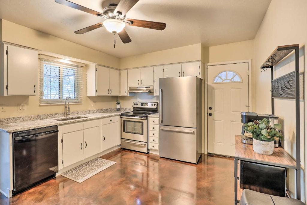 土桑Sunny Tucson Abode with Fire Pit 9 Mi to U of A的厨房配有白色橱柜和不锈钢冰箱