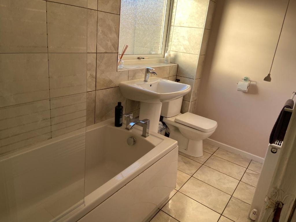 LemingtonLarge spacious 3 bedroom house Westerhope的浴室配有盥洗盆、卫生间和浴缸。
