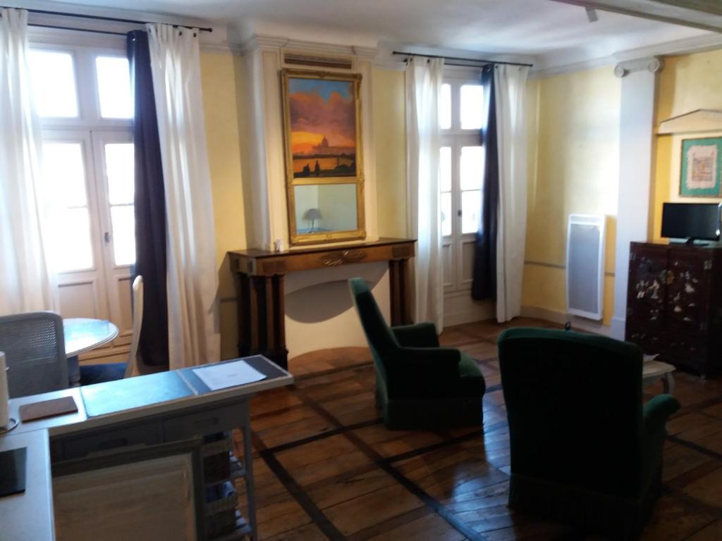 Grenade-sur-lʼAdourStudio de Tourisme Tilleuls的客厅配有桌子、椅子和窗户