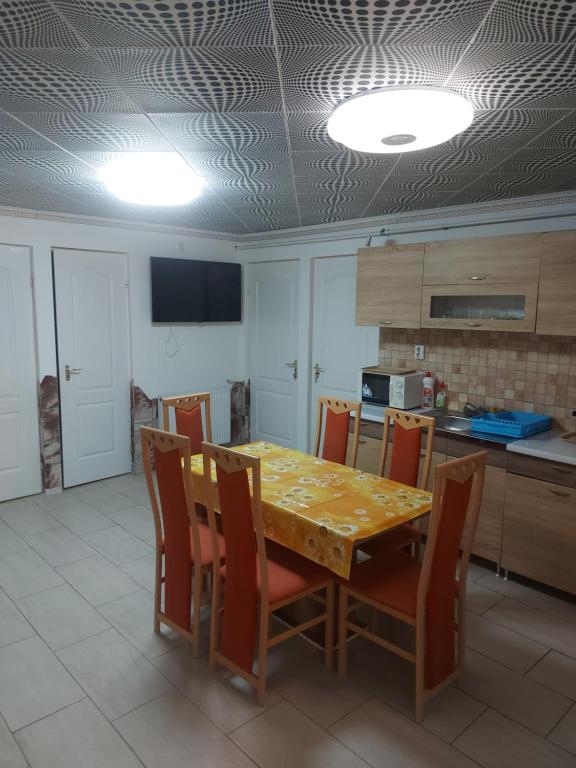 蒂萨新城Alexandra vendégház的厨房配有餐桌和椅子