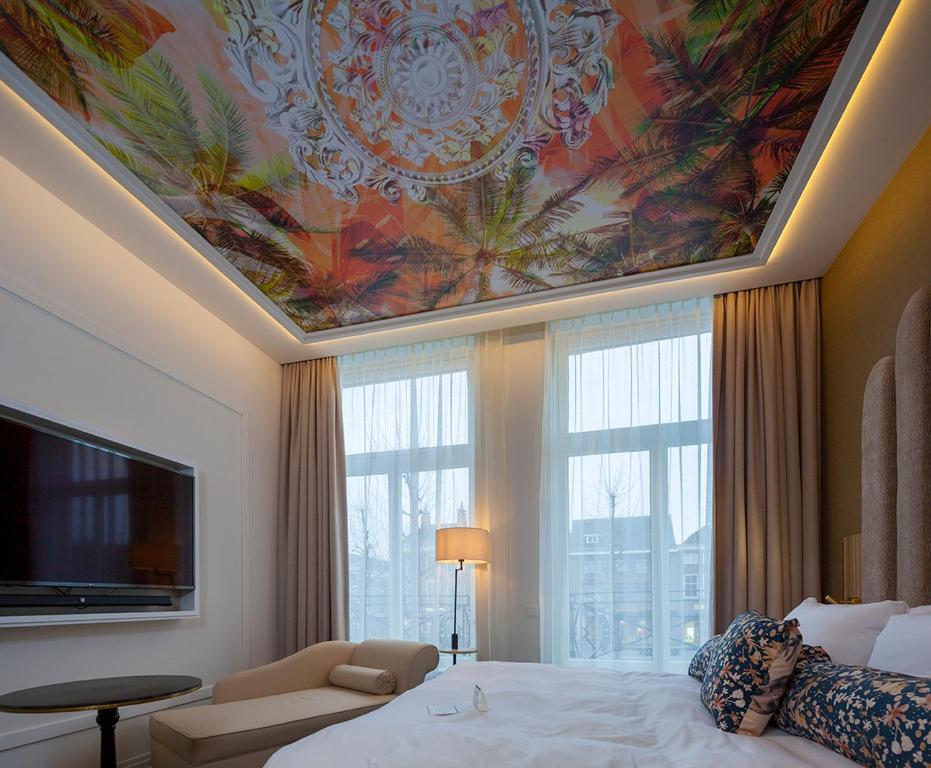 戈伊斯Boutique Hotel Jersey的酒店客房的天花板上装饰有绘画作品