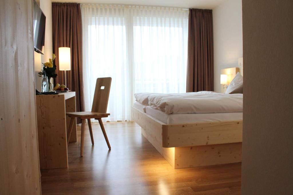 Sigmaringendorf贝姆瑞德维特酒店的卧室配有床、椅子和窗户。