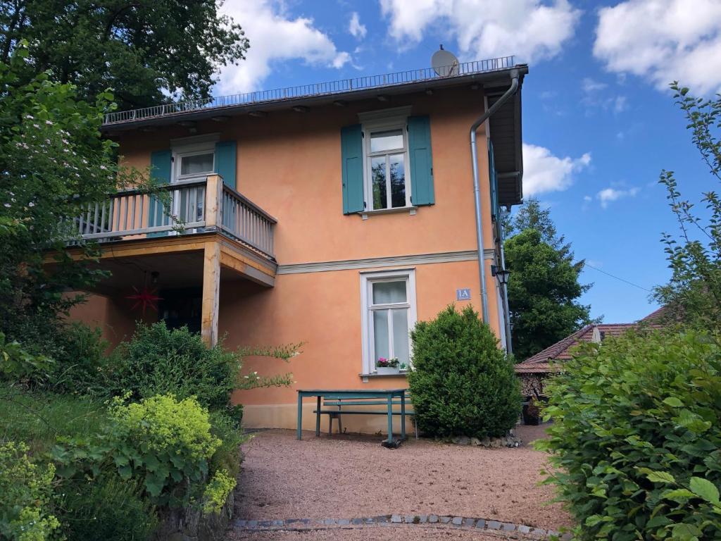 艾森纳赫Ferienhaus Eisenach的带阳台的房子,前面设有长凳
