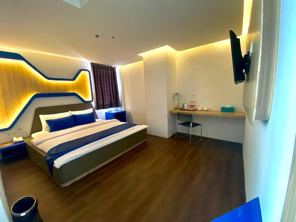 Batu MerahGolden Palace Hotel的一间卧室配有一张大床和一张书桌