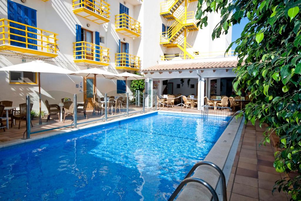 卡拉纳雅达Hotel Bellavista的游泳池,带椅子和遮阳伞