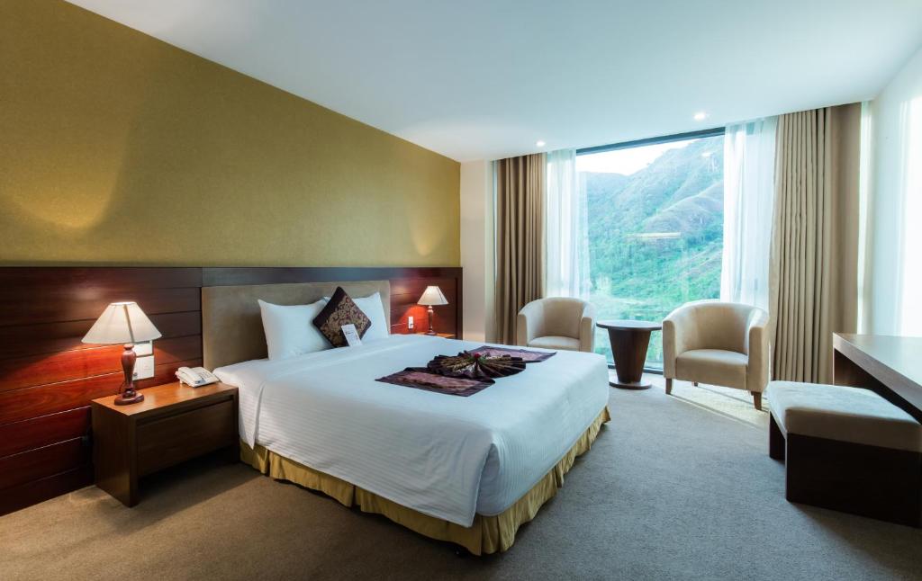 芽庄芽庄芒青大酒店的酒店客房设有一张床和一个大窗户