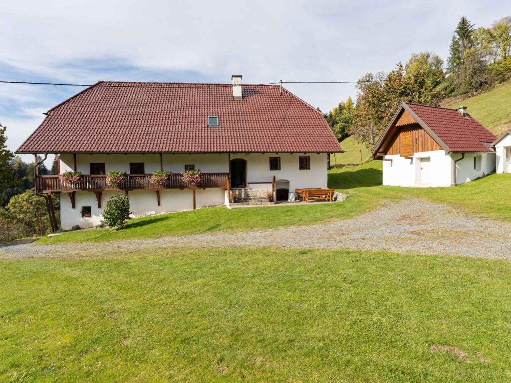 EbersteinHoliday home in Eberstein Carinthia with sauna的山坡上一座白色房子,屋顶红色