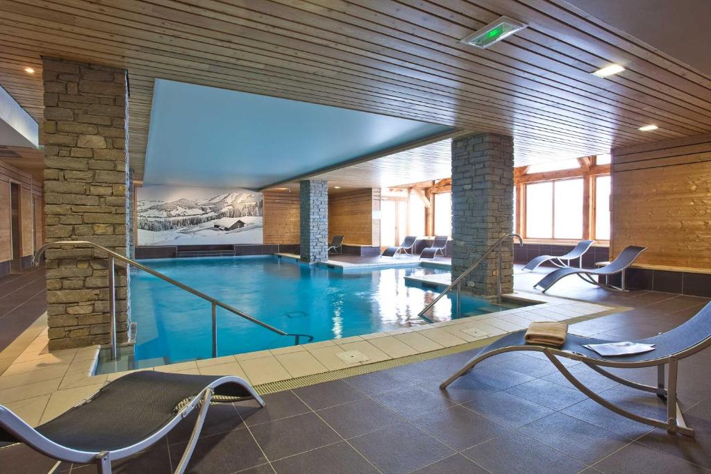 里蒙纽耶雷斯当斯夏雷瓦隆峰酒店的一座带椅子的大型游泳池