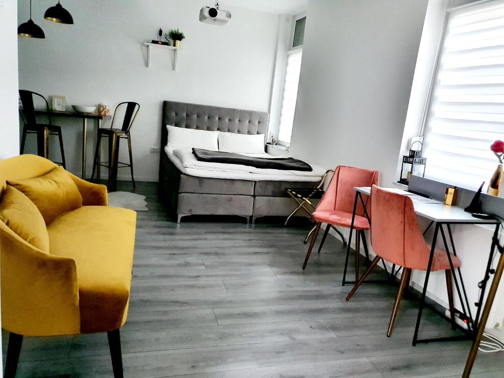 奥斯纳布吕克CITYLIFE Apartments Osnabrück mit E-Ladesäule的配有床、椅子和桌子的房间