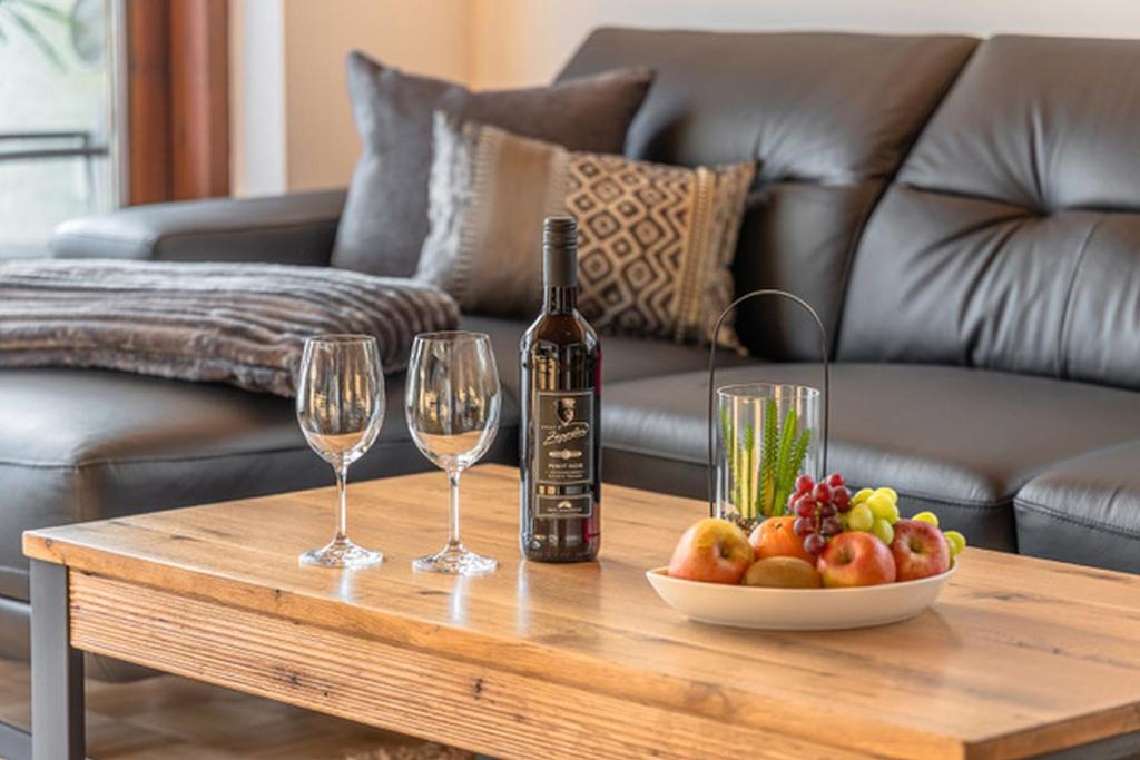 腓特烈港Comfort Apartment Buchhorn的一张桌子,上面放着一瓶葡萄酒和两杯酒杯