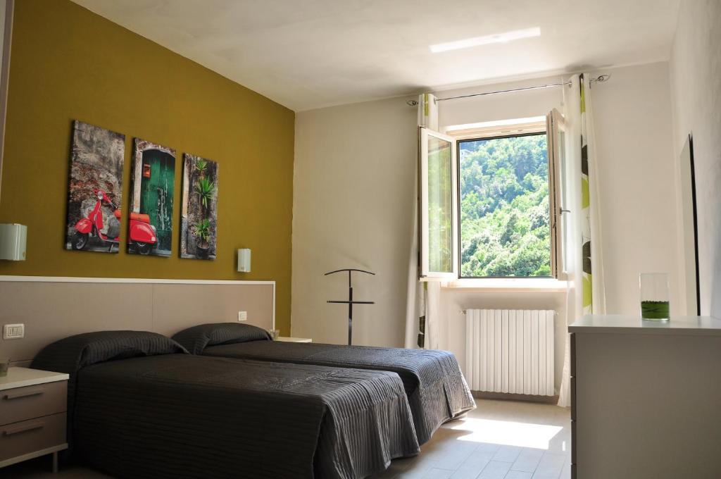 特雷莫西内必安度假屋的一间卧室设有一张黑色的床和一个窗户。
