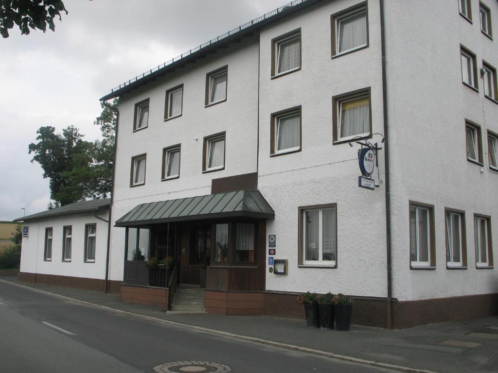 塞尔比茨Gasthof-Pension Leupold的街道边的白色大建筑
