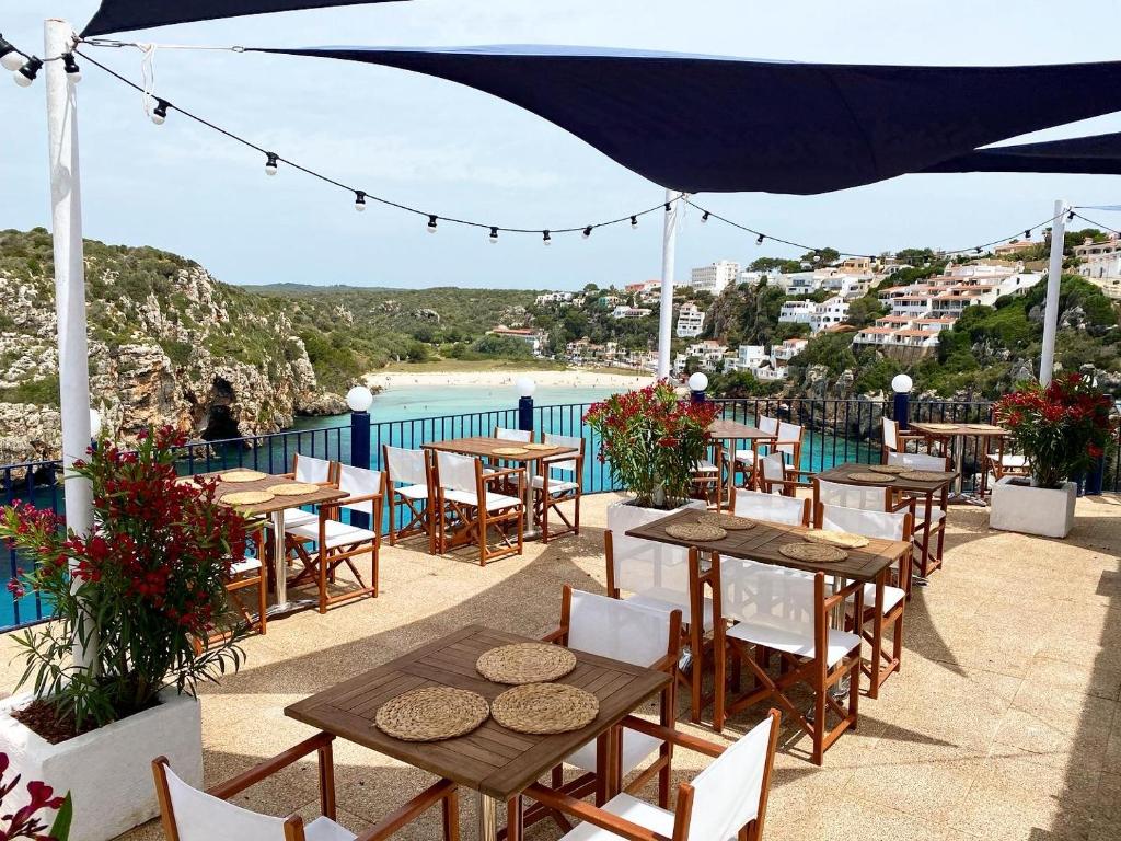 卡拉恩波特Club Menorca - Solo Adultos的一个带桌椅的庭院,享有水景