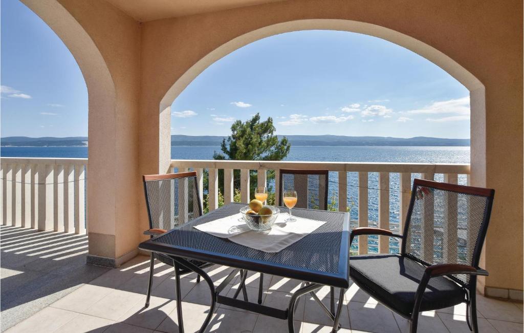 塞莱纳Gorgeous Apartment In Stanici With Kitchen的海景阳台上的桌椅