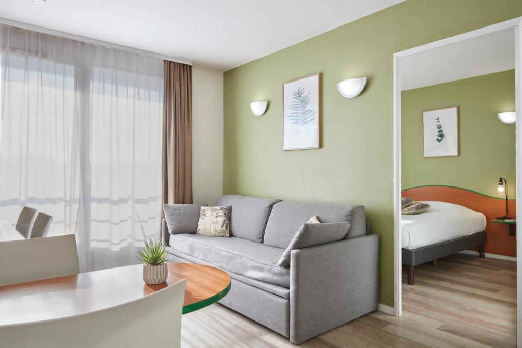 波尔多波尔多罗德萨阿德吉奥公寓式酒店的带沙发的客厅和卧室