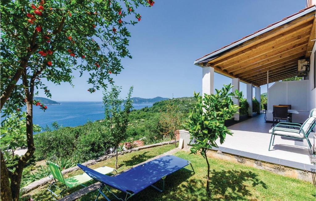 奥拉萨奇Stunning Apartment In Orasac With House Sea View的凉廊上配有蓝色椅子和桌子的房子