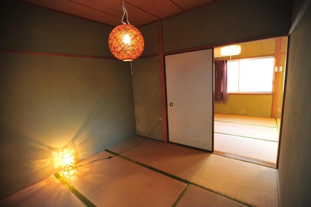 长崎长崎卡盖米亚旅舍的一个空房间,有门和灯具