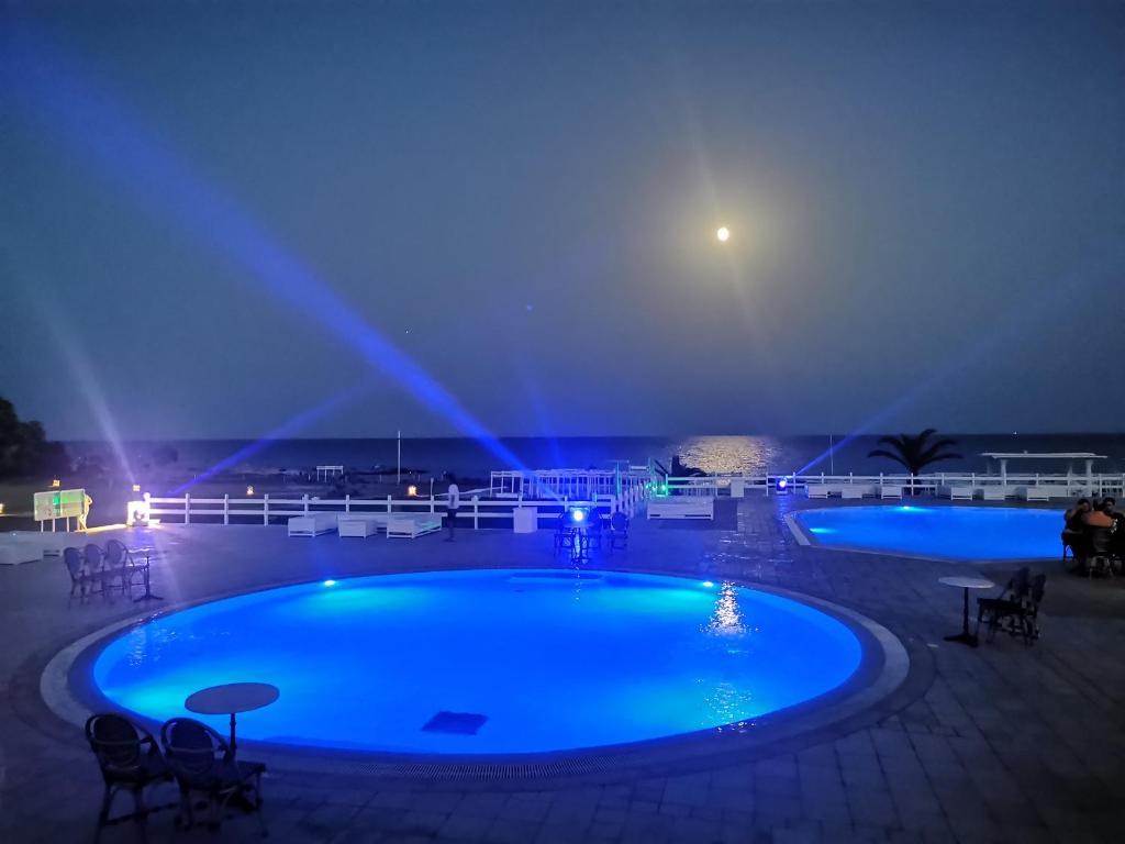 古莱比耶Cap Bon Kelibia Beach Hotel & Spa的夜晚的游泳池,灯光蓝色