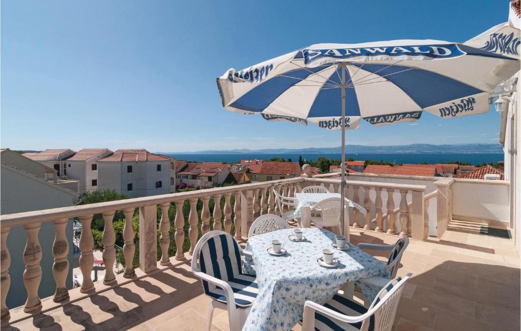 苏佩塔尔Gorgeous Apartment In Supetar With House Sea View的阳台上配有带雨伞的桌子