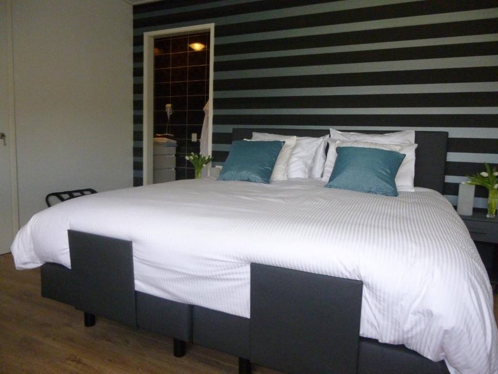 兹沃勒德兰根里住宿加早餐旅馆的一张配有白色床单和蓝色枕头的大床