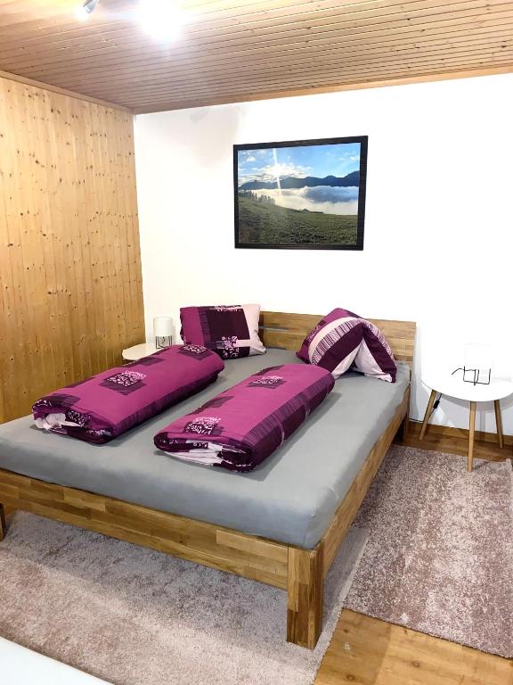 楚奥茨Günstig und Einfaches Studio auf dem Bauernhof的一张床上的床铺,上面有紫色枕头