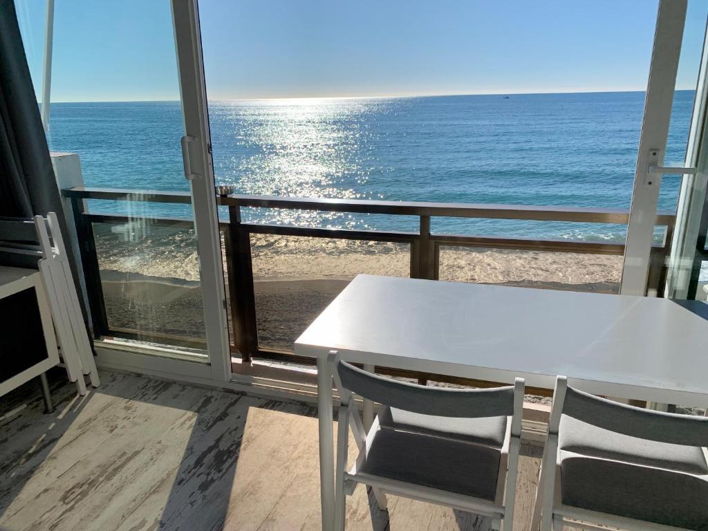 贝纳尔马德纳Malibu - “Vive en la playa” “Live on the beach”的阳台上配有白色的桌椅,享有海景