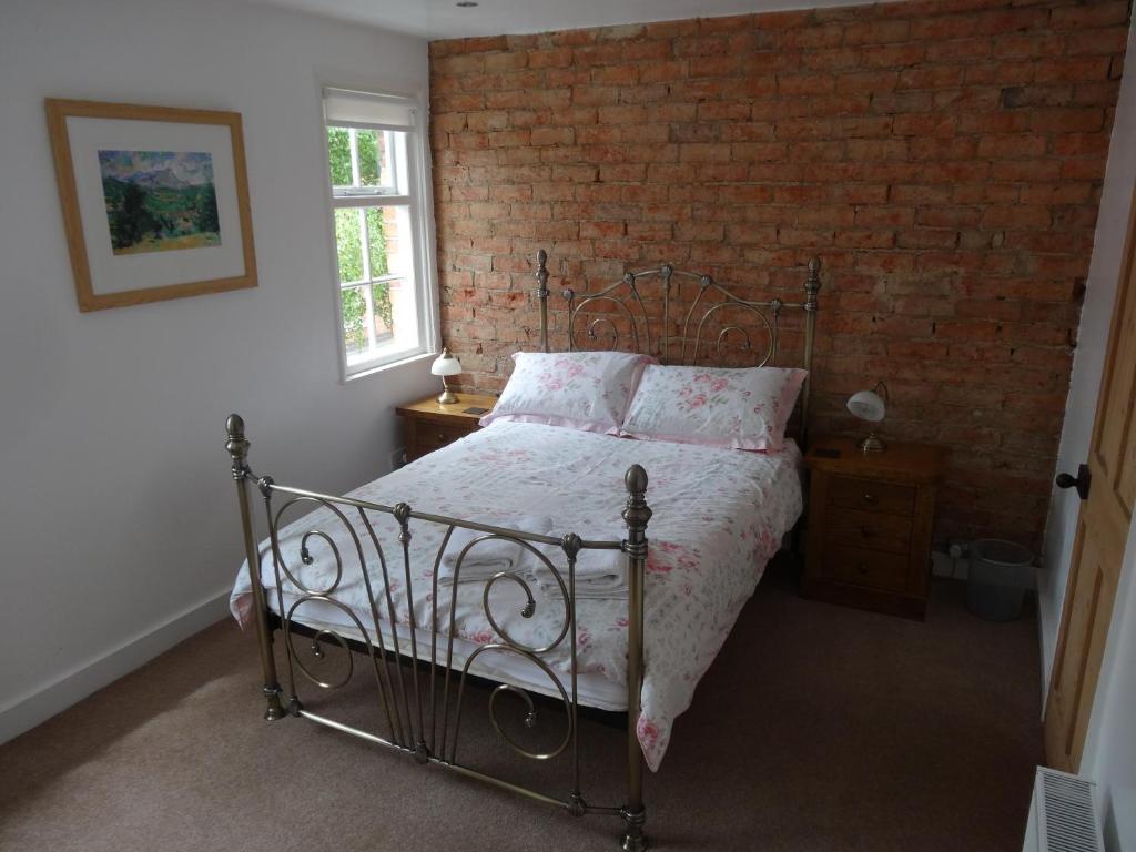 林肯磨房路22度假屋酒店的一间卧室设有一张床和砖墙