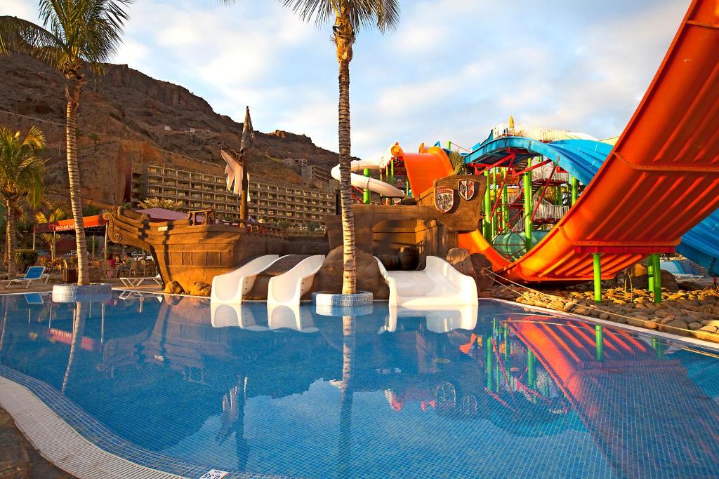 塔乌里托Hotel LIVVO Lago Taurito & Aquapark的一个带水滑梯的主题公园的游泳池