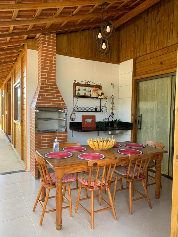 安谢塔Pousada Portal da Praia的厨房配有木桌、椅子和炉灶